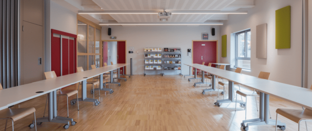 Salle de réunion avec tables et chaises modernes.