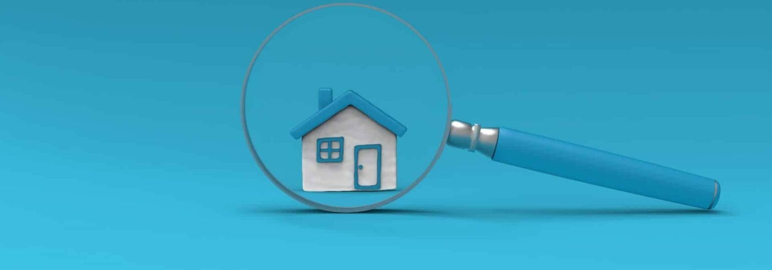 Maison sous une loupe bleue.
