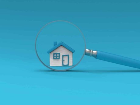 Maison sous une loupe bleue.