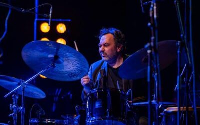 Homme jouant de la batterie sur scène.