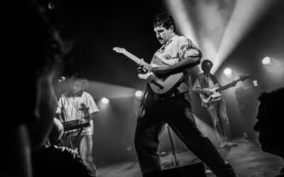 Concert rock avec guitariste sur scène.