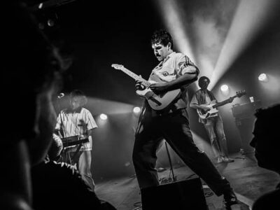 Concert rock avec guitariste sur scène.