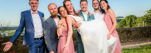 Mariage : amis portant la mariée souriante.