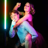 Deux personnes posant sous lumières colorées.