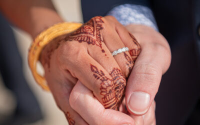 Mains entrelacées avec henné et bague.