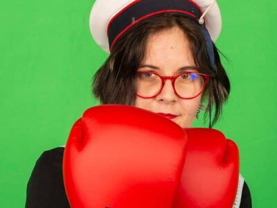 Personne avec gants de boxe rouges, fond vert.