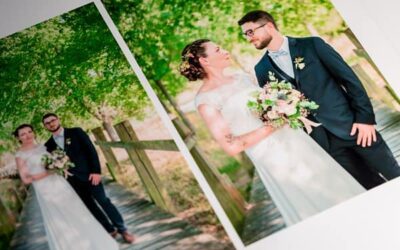 Album de mariage, couple souriant sur passerelle boisée.