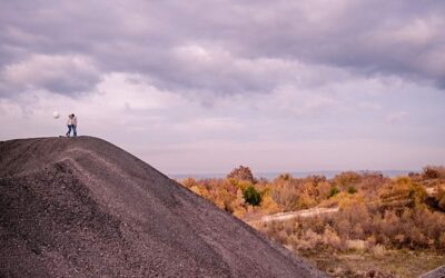 Personne debout sur une colline sombre, ciel nuageux.