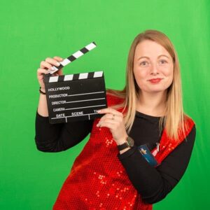 Femme tenant un clap de cinéma, fond vert.