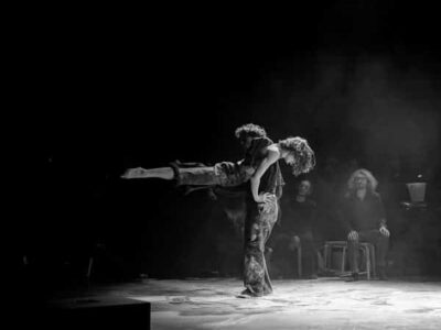 Duo de danseurs sur scène, lumière tamisée.