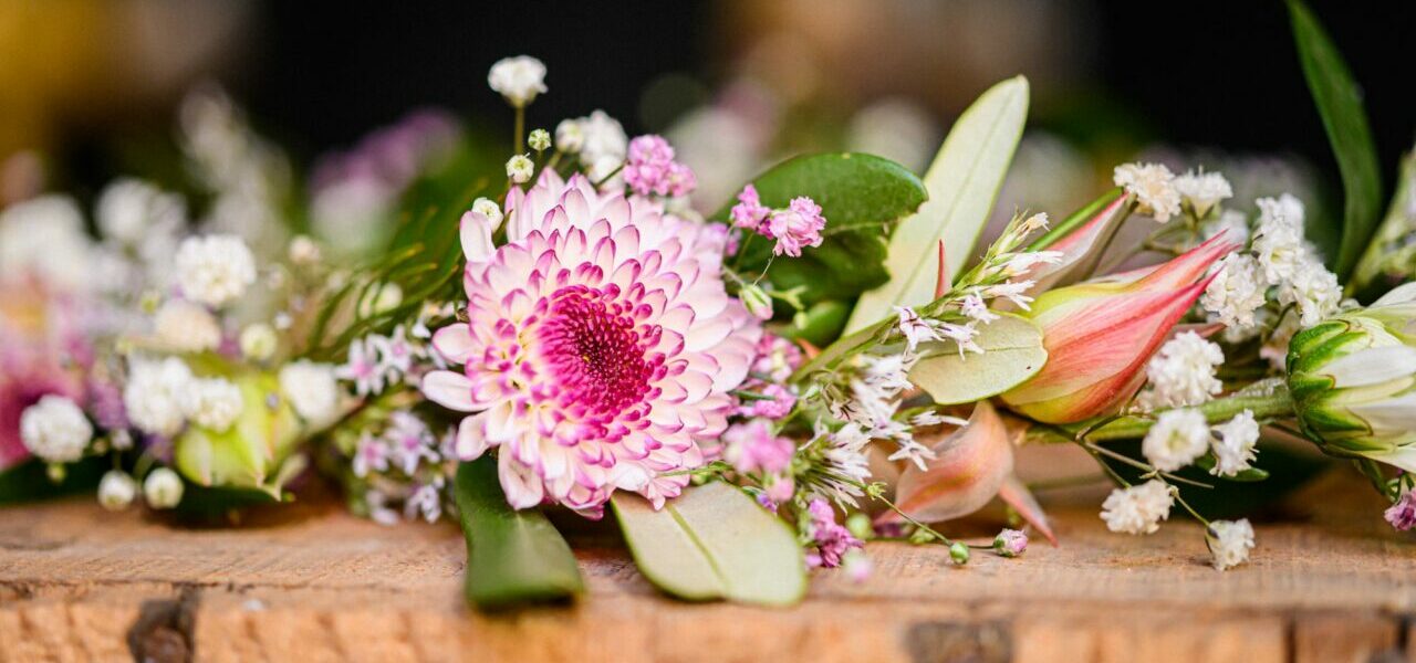 Bouquet de fleurs colorées sur table en bois.