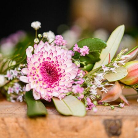 Bouquet de fleurs colorées sur table en bois.