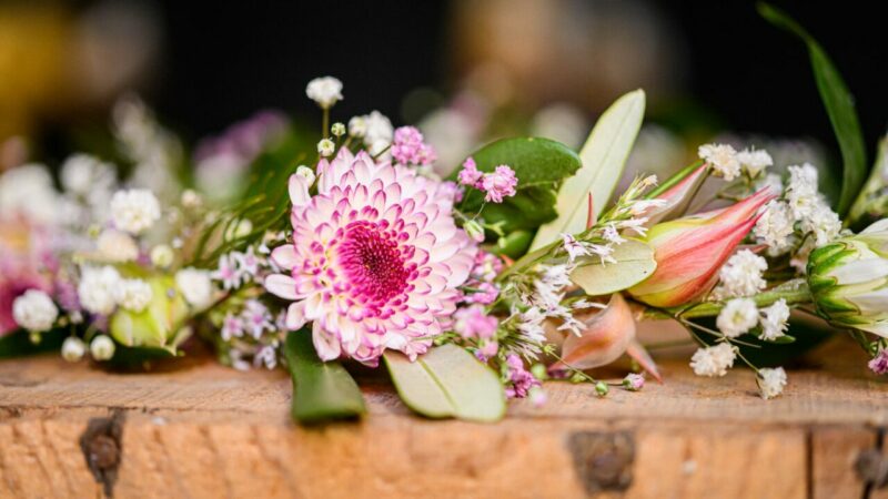 Bouquet de fleurs colorées sur table en bois.
