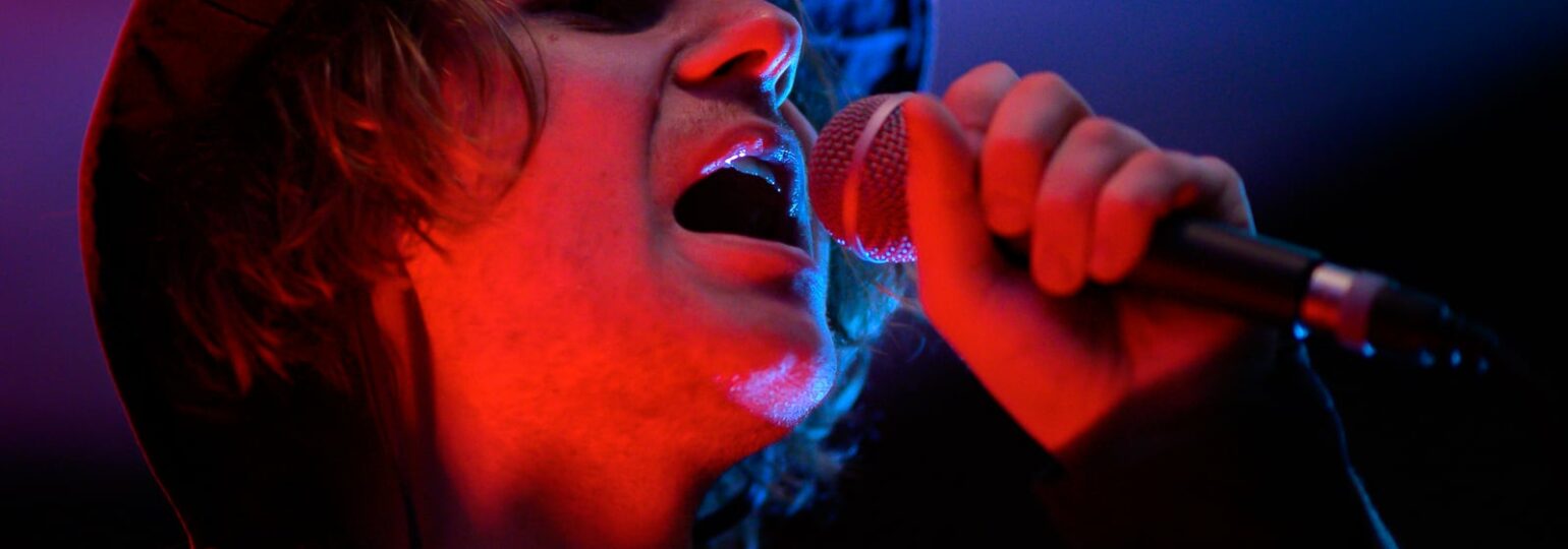 Chanteur avec micro, ambiance lumineuse.