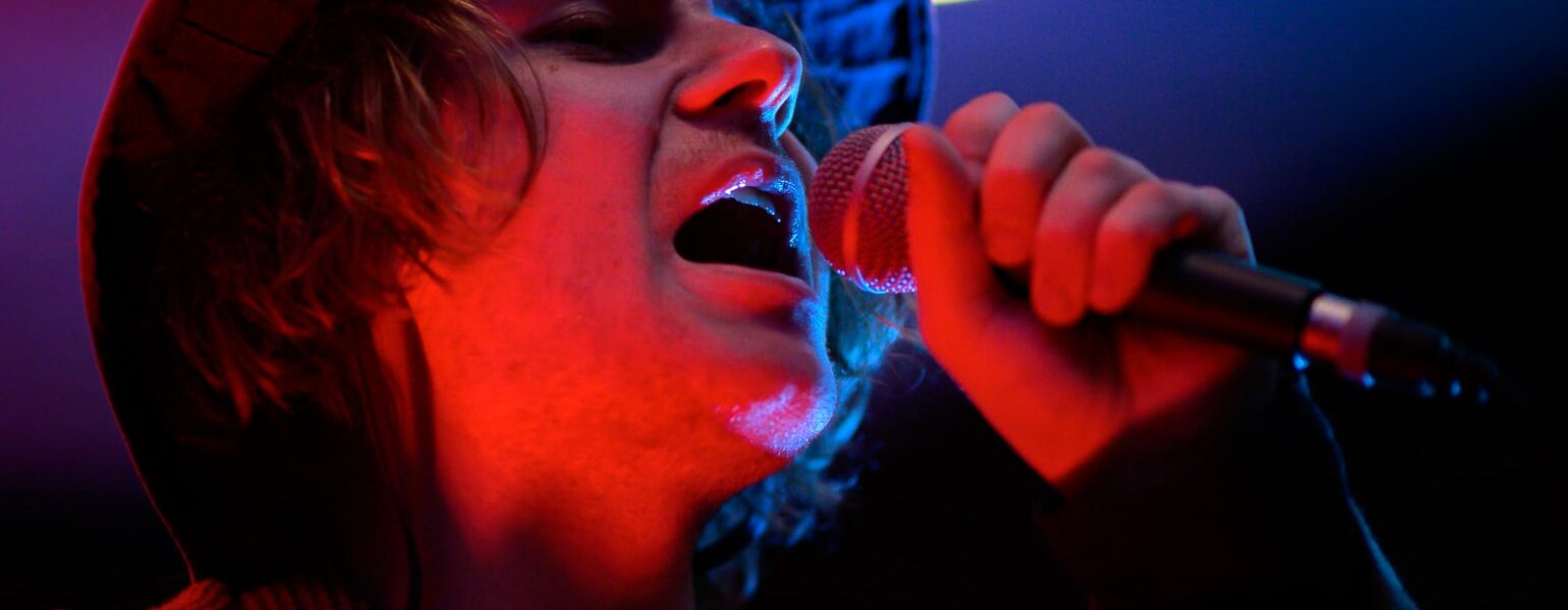 Chanteur avec micro, ambiance lumineuse.