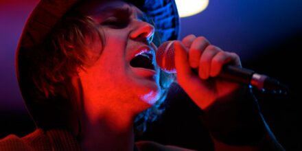 Chanteur avec micro, ambiance lumineuse.