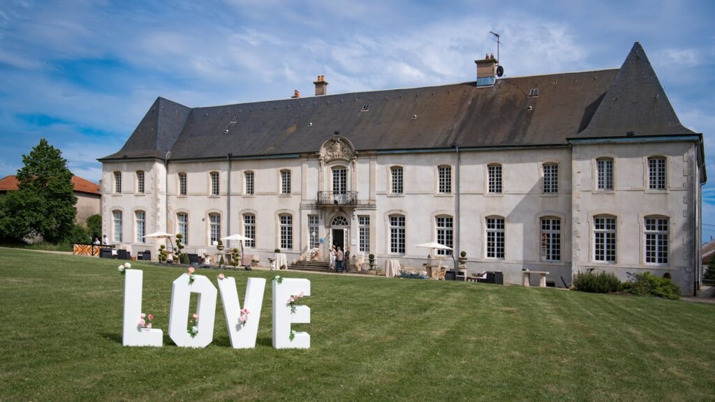 Château français avec lettres LOVE sur pelouse.