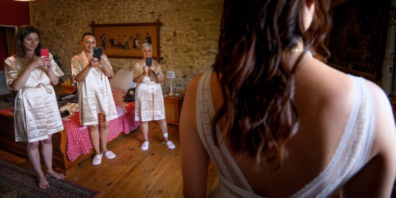 Femmes en peignoirs désaturés photographiant une mariée