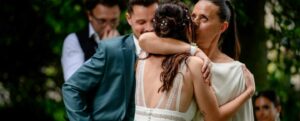 Deux femmes s'embrassent lors d'une cérémonie en plein air.