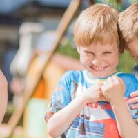 Enfants souriant et jouant dehors en été.