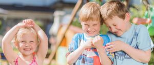 Enfants souriant et jouant dehors en été.