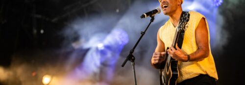 Chanteur sur scène avec une guitare.