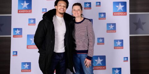 Deux personnes souriant devant logo Kinepolis.