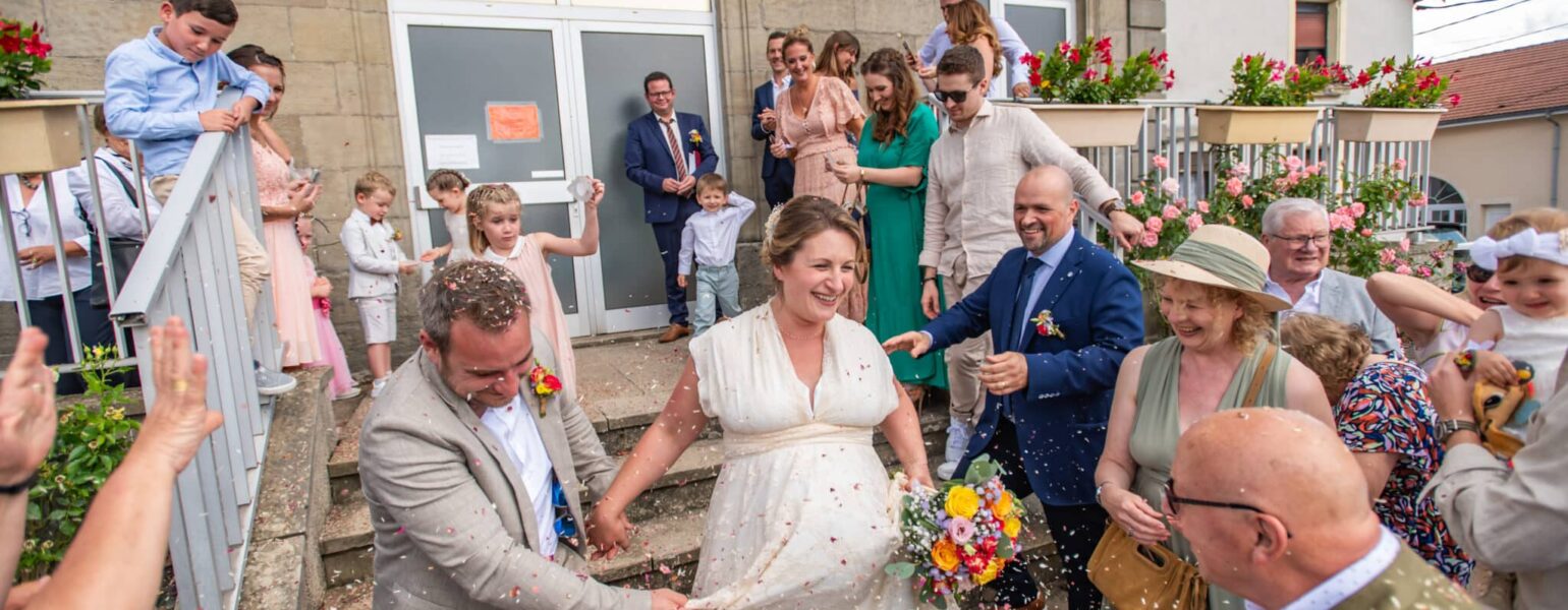 Sortie de mariage des mariés sous pluie de confettis.
