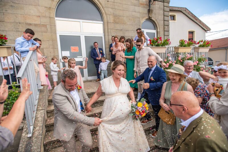 Sortie de mariage des mariés sous pluie de confettis.