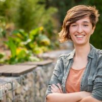 Personne souriante dans un jardin verdoyant