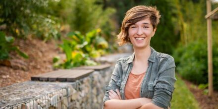 Personne souriante dans un jardin verdoyant