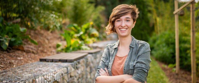 Personne souriante dans un jardin verdoyant
