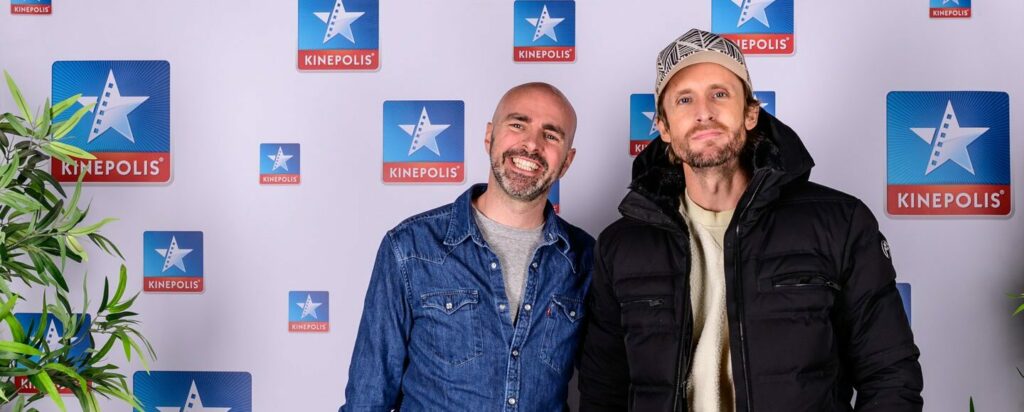 Deux personnes posent devant un logo Kinepolis.