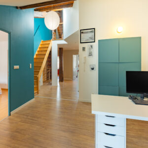 Intérieur moderne avec bureau et escalier.