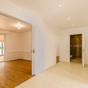 Salon lumineux avec parquet et terrasse.