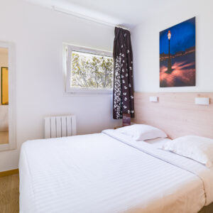 Chambre minimaliste avec lit double, décoration élégante.