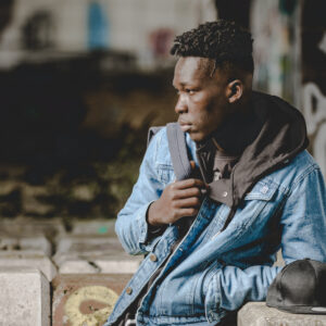 Homme pensif en veste en jean, extérieur urbain.