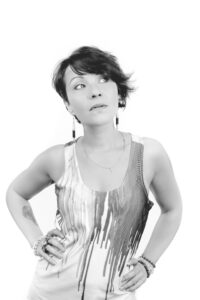 Femme avec chemise artistique et tatouage, noir et blanc.