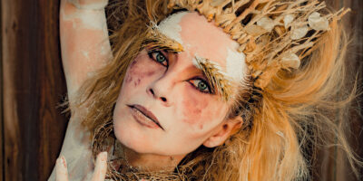 Personne maquillée avec une couronne de branches.