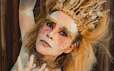 Personne maquillée avec une couronne de branches.