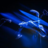 Musicien jouant de la flûte en lumière bleue