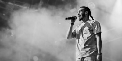 Chanteur sur scène, microphone en main.