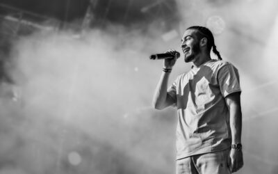 Chanteur sur scène, microphone en main.