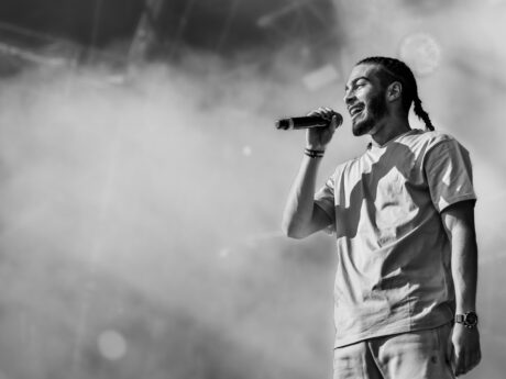 Chanteur sur scène, microphone en main.