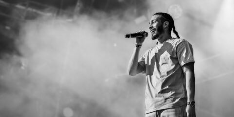 Chanteur sur scène, microphone en main.