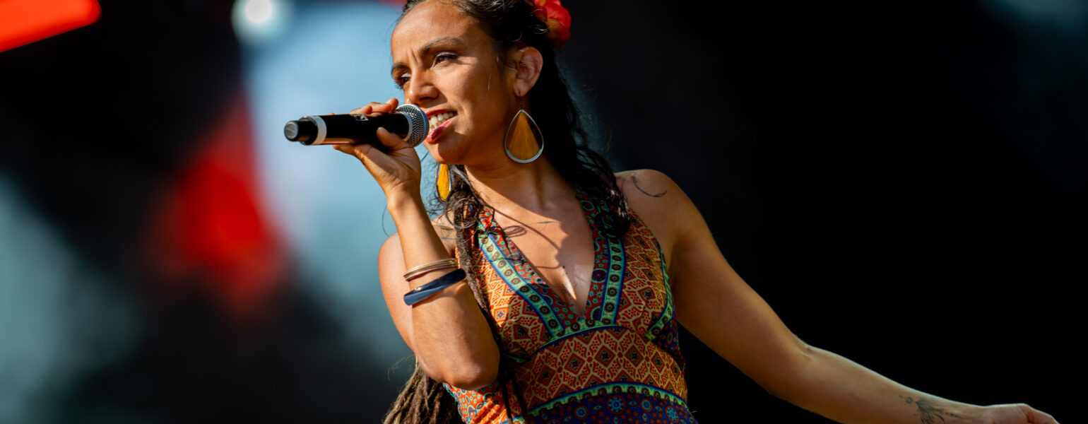 Chanteuse sur scène avec micro et robe colorée.