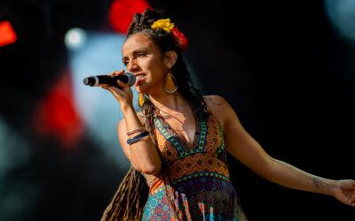 Chanteuse sur scène avec micro et robe colorée.