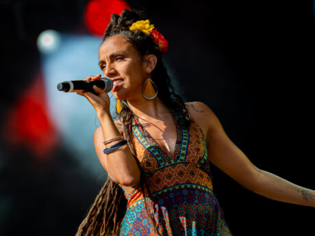 Chanteuse sur scène avec micro et robe colorée.