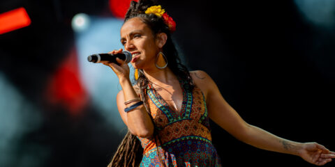 Chanteuse sur scène avec micro et robe colorée.