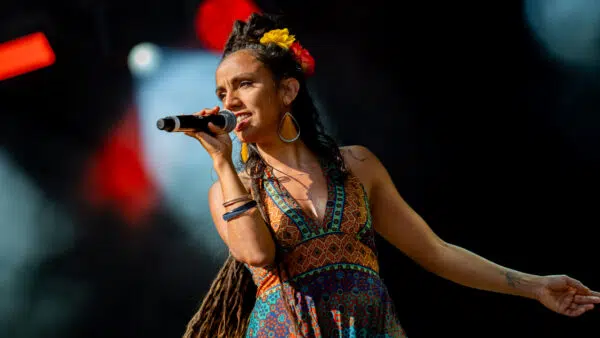 Chanteuse sur scène avec micro et robe colorée.